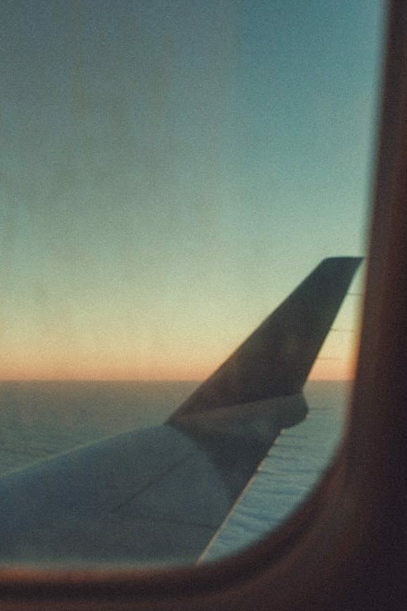 Plane flying above the blue ocean